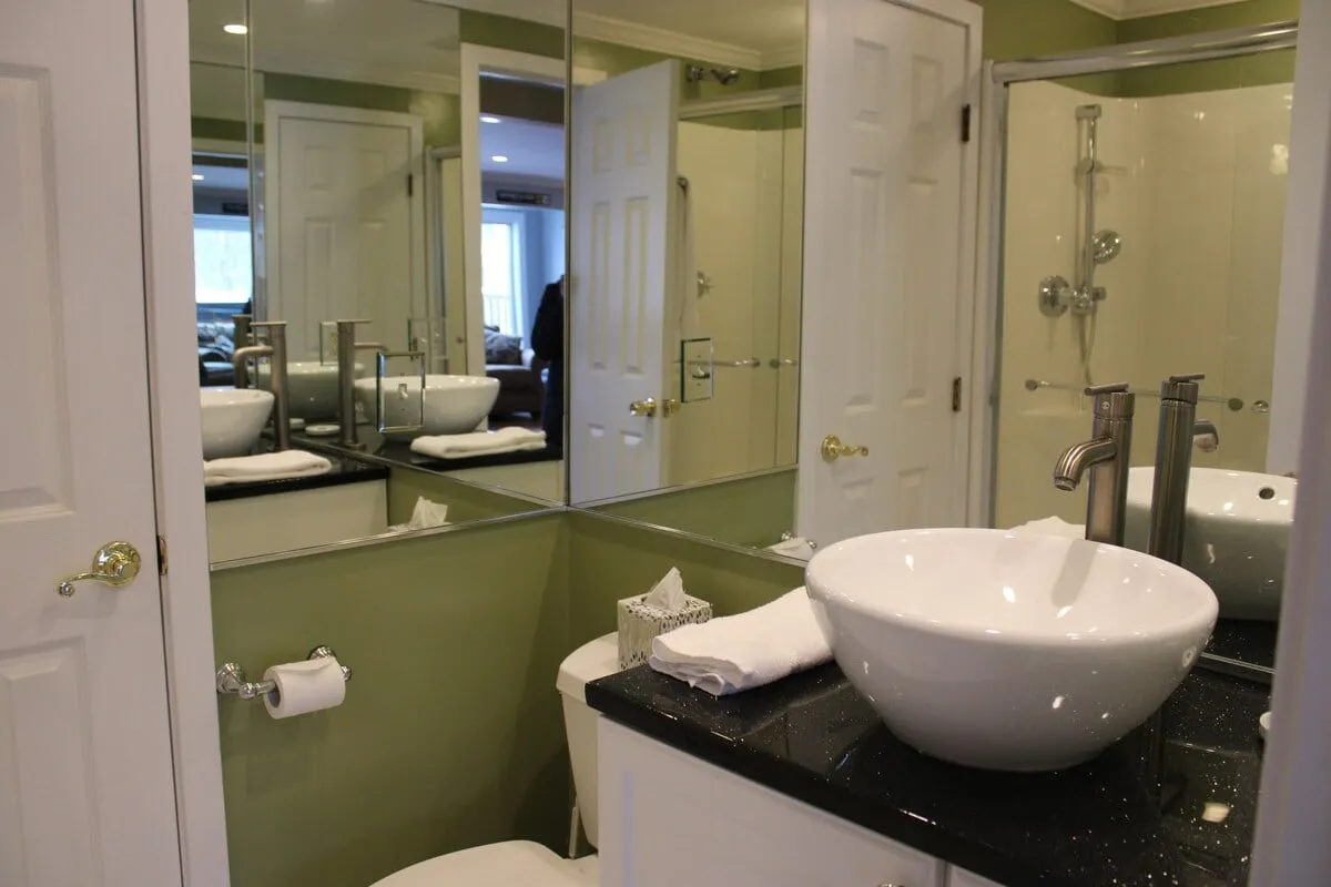 A bright, contemporary bathroom with a sink, mirror, and shower. The clean lines and inviting mood make it ideal for both energizing morning routines and relaxing evening rituals.
