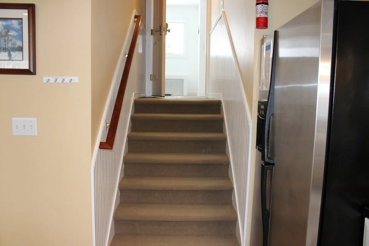 This interior shot highlights a staircase, kitchen appliance, and a doorway, with a layout that suggests easy flow between indoor and outdoor living. The presence of the doorway offers a subtle nod to the transition between exploring outside and relaxing inside, while the kitchen hints at preparing post-adventure meals.